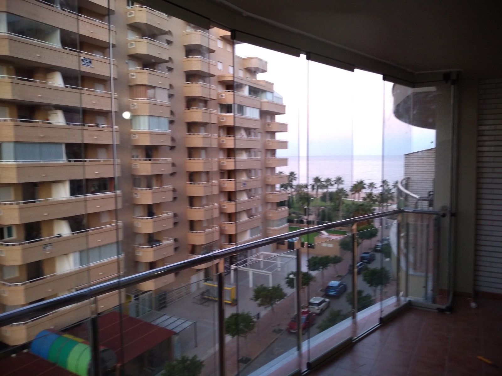 Cortinas de cristal instaladas en balcón de apartamento en Benidorm con vista al mar